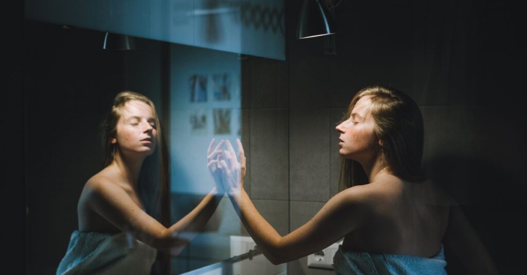 鏡の前で静かに自分と向き合う人。物語の登場人物に、自分自身を見つける瞬間。