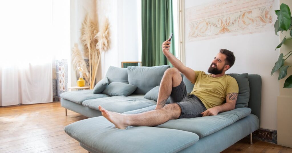 夜明けの光が部屋を満たすなか、窓のそばに立つ男性。こわばっていた肩が、ゆっくりとほどけていく静かな変化。