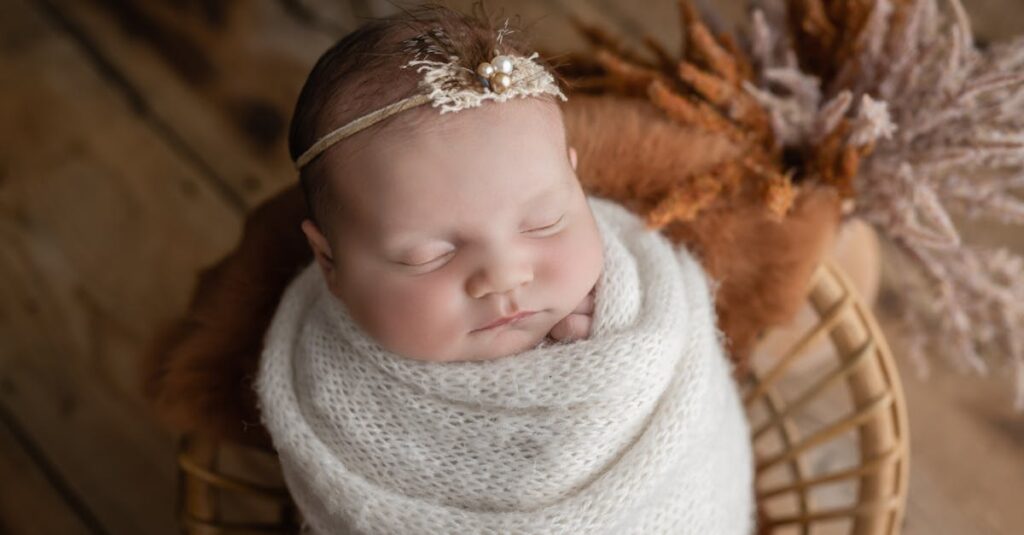 暖炉のそばの椅子で毛布にくるまって眠る子供。誰かがそっとかけてくれたような、安心のぬくもり。