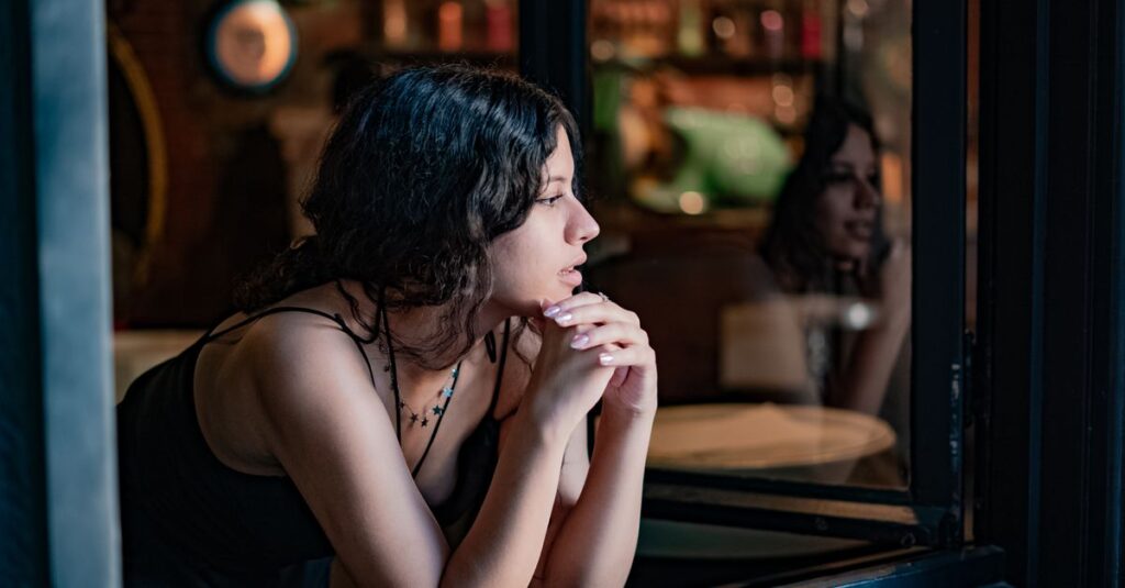 窓の外をそっと見つめながら恋心を抱える女性