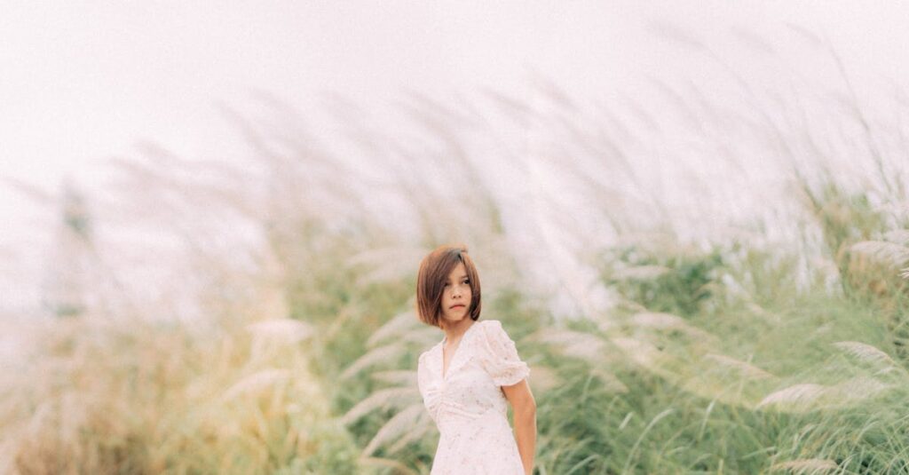 やわらかな風の中で静かに立つ女性。弱さを抱えながらも、凛と立つ姿。