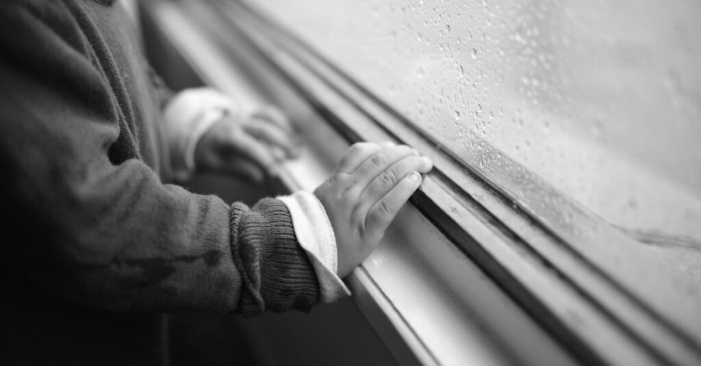 雨の窓辺でひとり静かに座る人。過去と静かに向き合う、やわらかな時間。