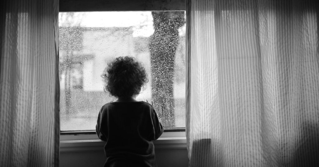 雨の窓辺でひとり静かに座る人。過去と静かに向き合う、やわらかな時間。