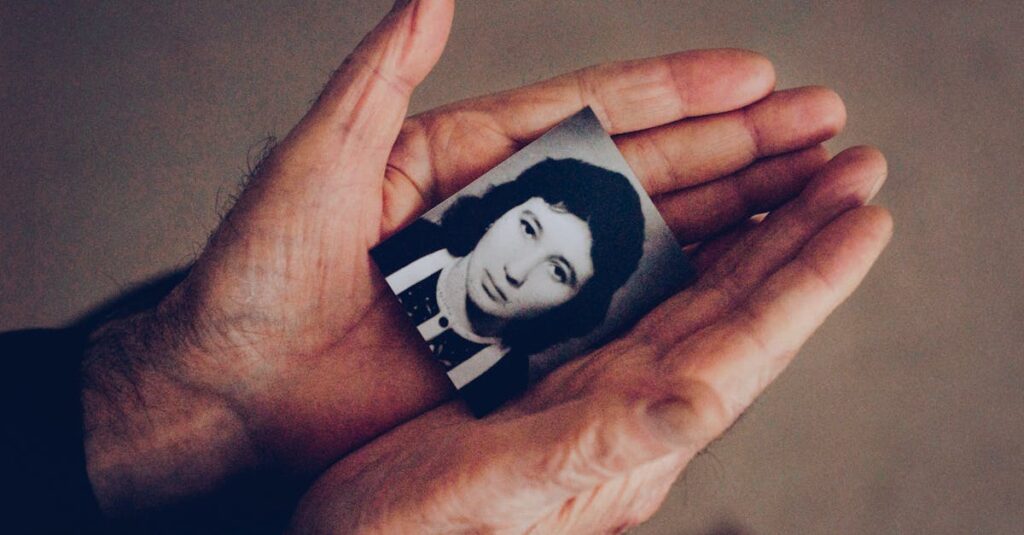 古い写真をそっと手に取る女性。過去を受け入れ、静かに前を向く姿。