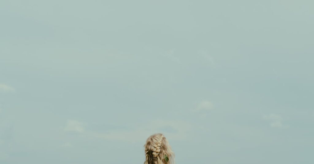 やわらかな風の中で静かに立つ女性。弱さを抱えながらも、凛と立つ姿。