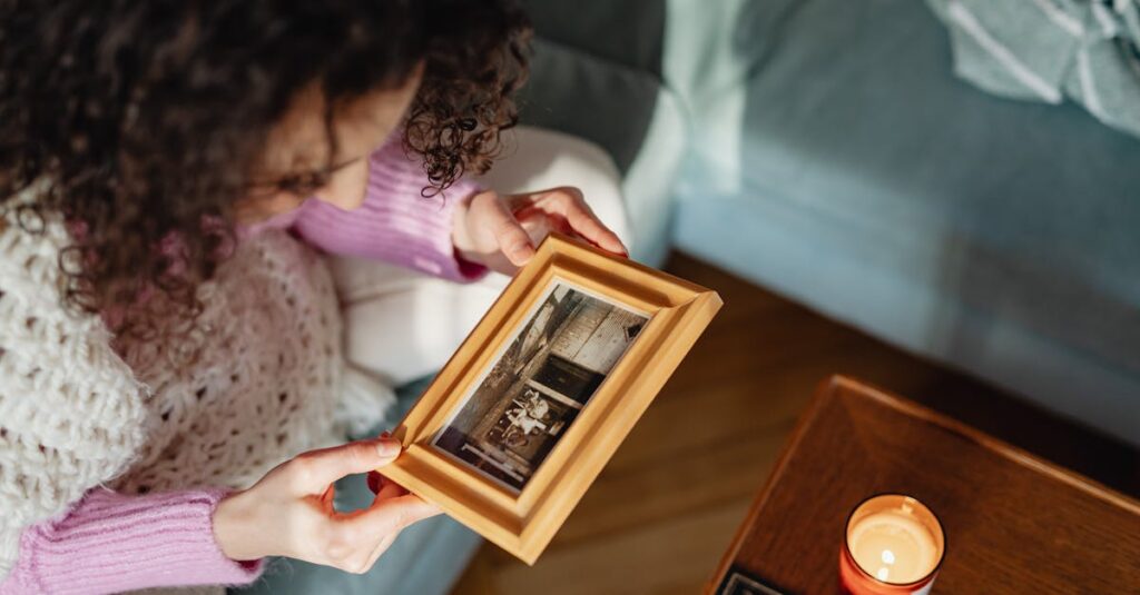 古い写真をそっと手に取る女性。過去を受け入れ、静かに前を向く姿。