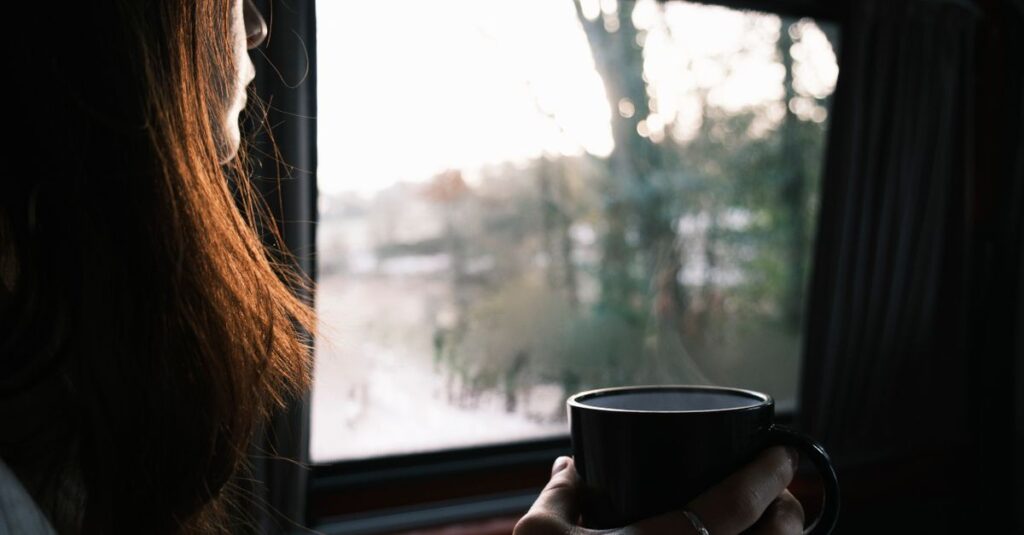窓辺で静かにお茶を飲む女性。自分を取り戻すための、やわらかな時間。