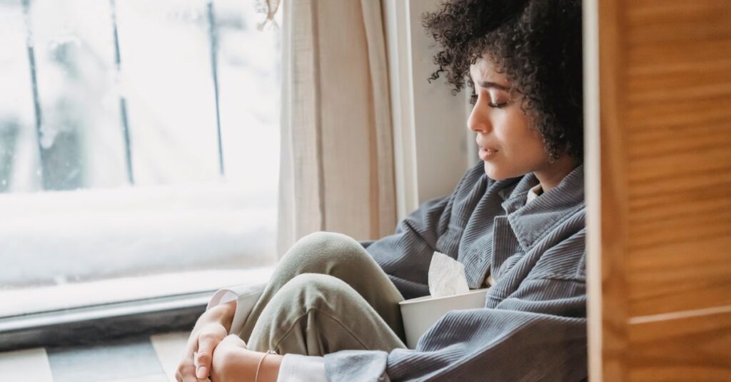 窓辺で静かにひとり休む人。人づきあいに疲れたとき、ひとりの時間が心をほどいてくれる。