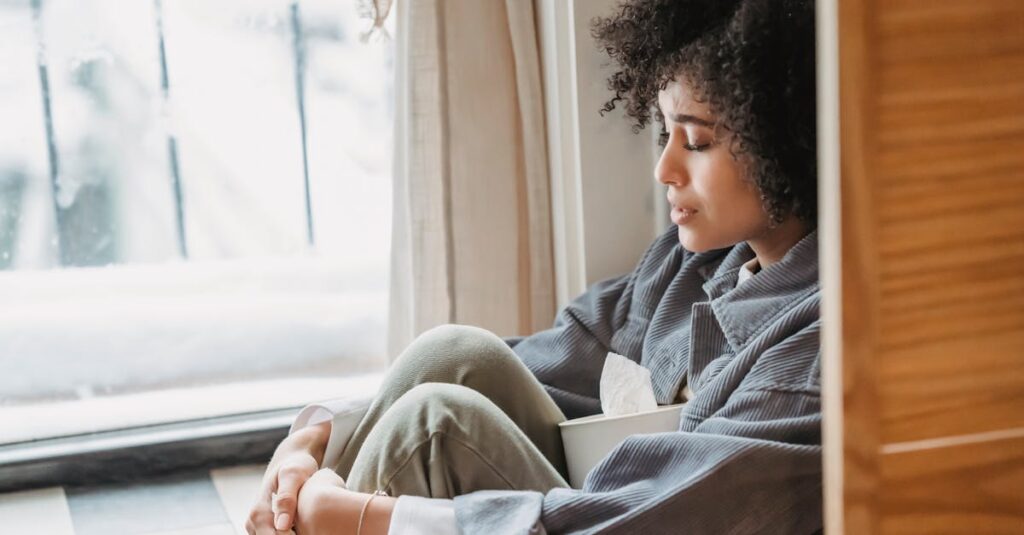 窓辺で静かにひとり休む人。人づきあいに疲れたとき、ひとりの時間が心をほどいてくれる。