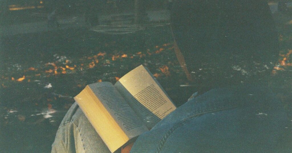 やわらかな灯りの中で本を閉じる人。読み終えたのに、心の中ではまだ物語が続いている。