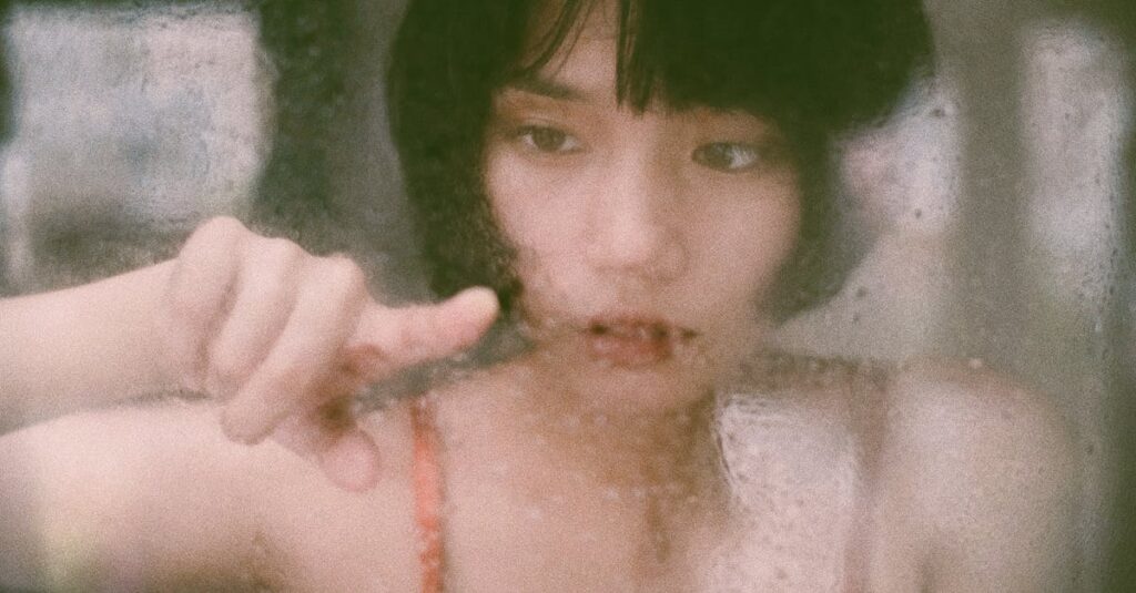 雨の窓辺でひとり静かにいる女性。言葉にならないまま抱えてきた感情が、ある日静かに溢れる。