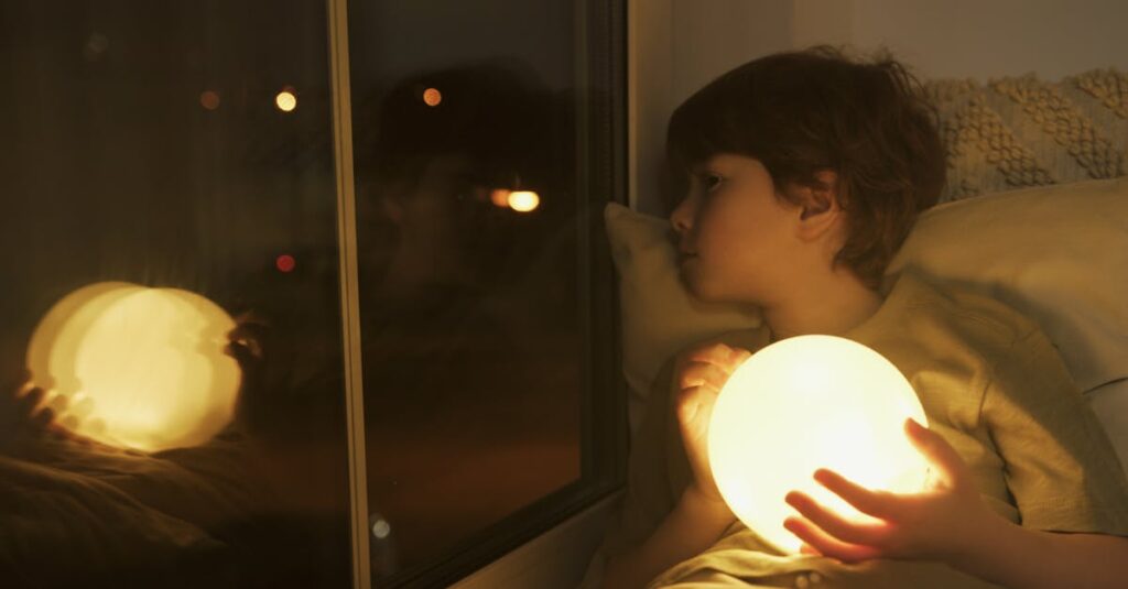 舞台の隅で一人座るアニメキャラクター、自分の出番を諦めたような姿