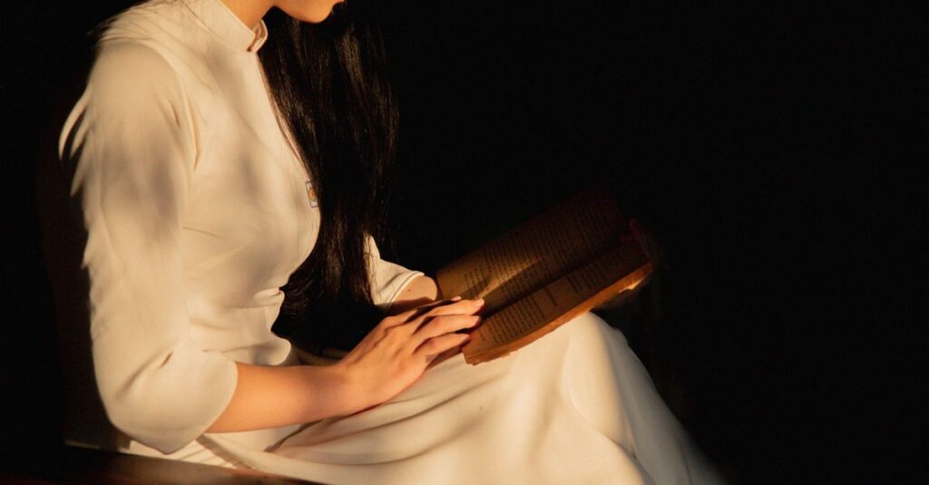 やわらかな光の中で静かに観察する女性。理性と孤独を抱えながら、真実を見つめ続けている。