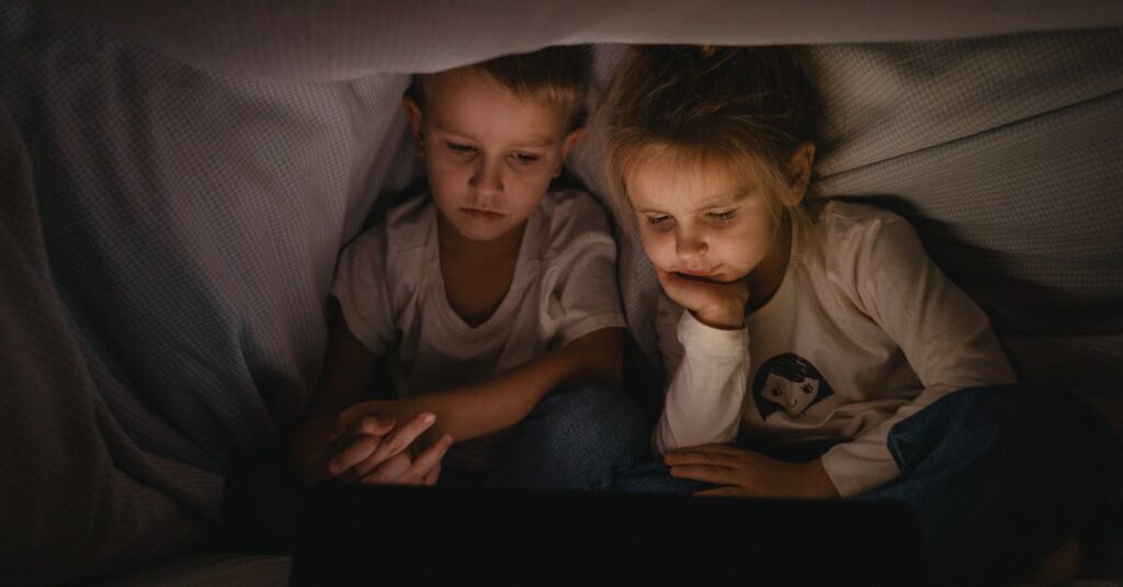 夜、毛布にくるまって画面を見つめる女の子。それだけで十分な、やさしい時間。