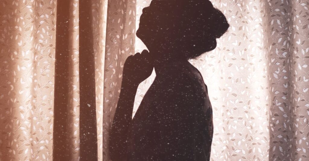 朝の光が差し込む窓辺で静かに座る女性。新しい一日を、やわらかく迎える準備。