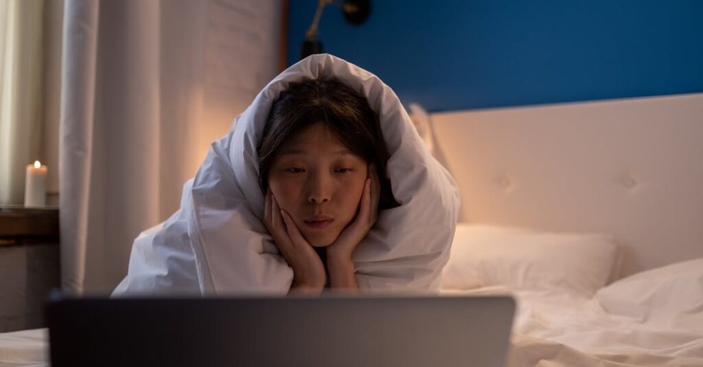 夜、毛布にくるまって画面を見つめる女の子。それだけで十分な、やさしい時間。
