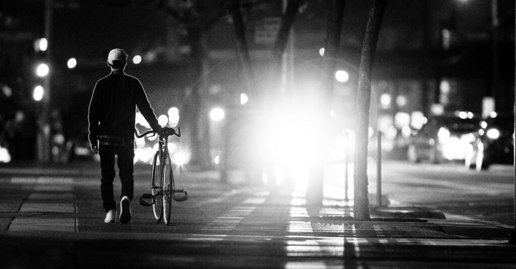 夜の街の光を見つめる女性。未来の不安と静かに向き合いながら、自分の心の声を探している。