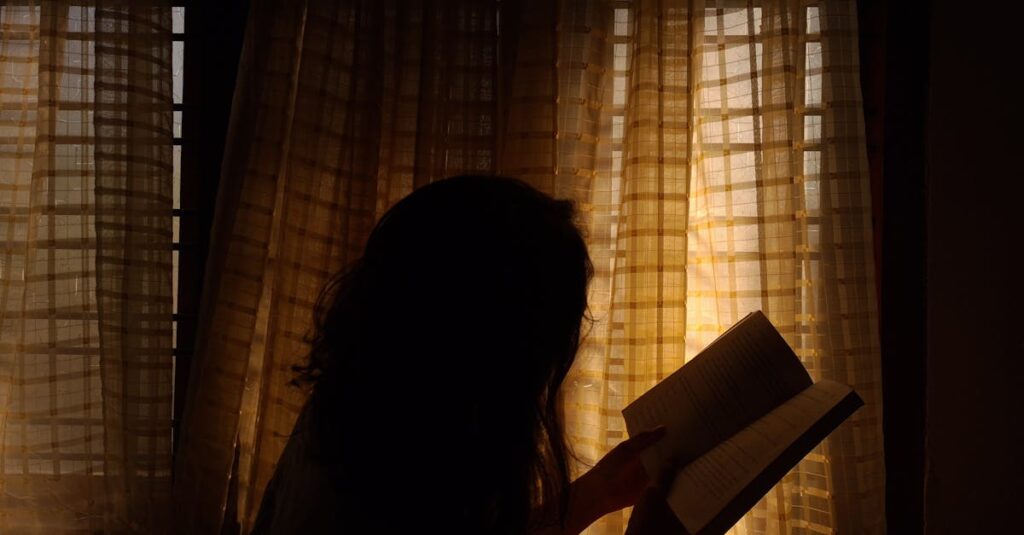 夜の静かな部屋で光を見つめる人。痛みの奥で、心はすでに回復を始めている。