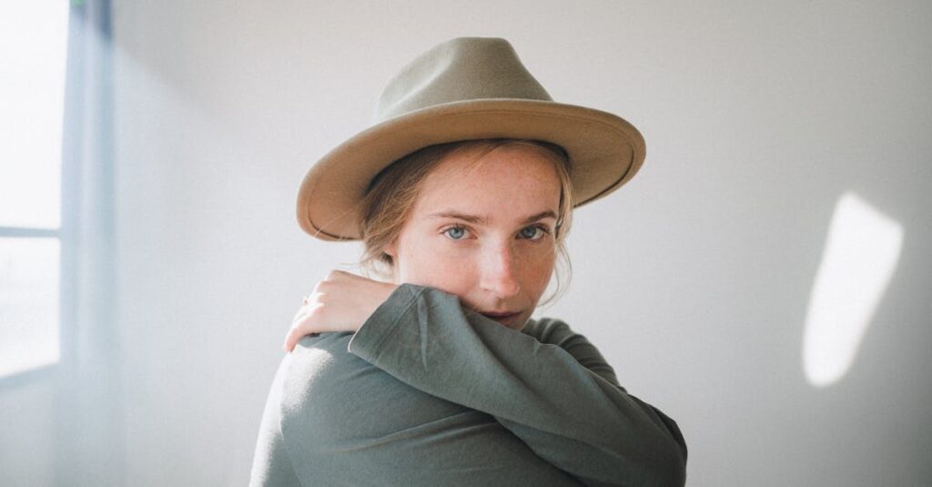 窓辺で少し肩の力を抜いて座る女性。頑張るのをやめてみた静かな時間を象徴する情景。