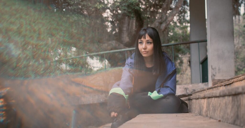 やわらかな光の中で静かに佇む女性。こわさを抱えたままでも十分だという静かな自信を象徴する風景。