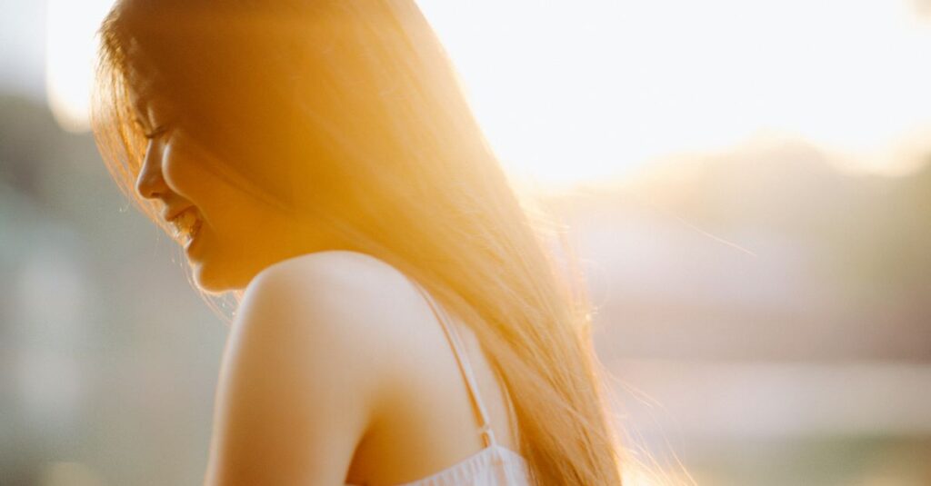 やわらかな光の中でほっとした表情の女性。感じることを許した後の静かな回復を象徴する風景。