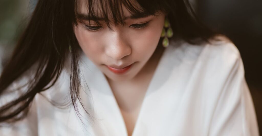 静かにうつむく女性。優しくできなかった日の後悔をそっと抱える時間を象徴する風景。