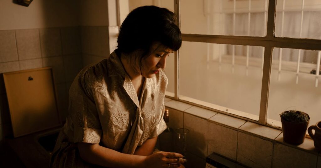 疲れた表情で静かに座る女性。愛されるための努力に消耗した日々を象徴する風景。