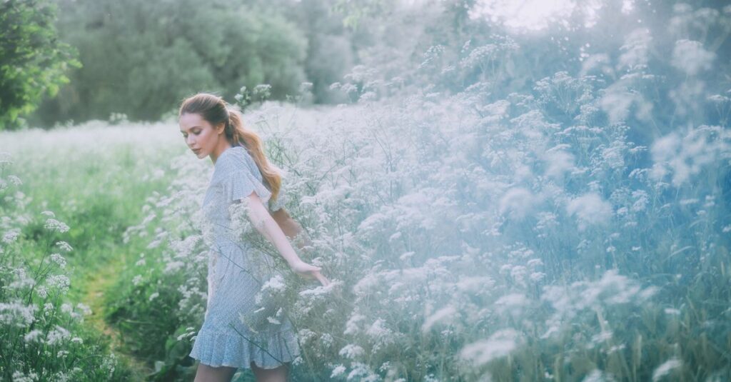 小道の脇でゆっくり花を摘む女性。急がない旅の穏やかな豊かさを象徴する風景。