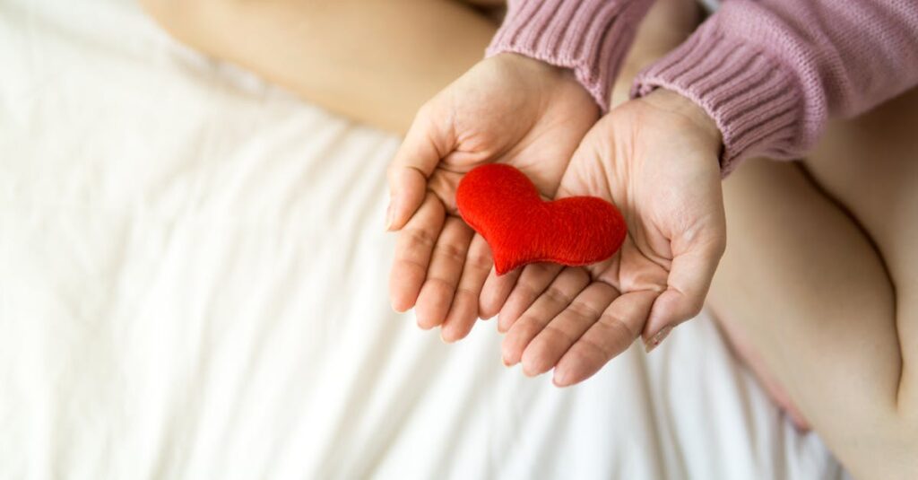 胸に手を当てて微笑む女性。自分を受け入れ、やさしく包み込む瞬間のイメージ。