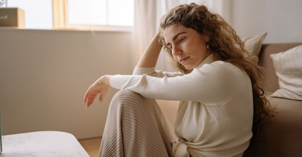 やわらかな光の中で静かに自分を受け取る女性。完璧じゃなくても、ここにいていい。
