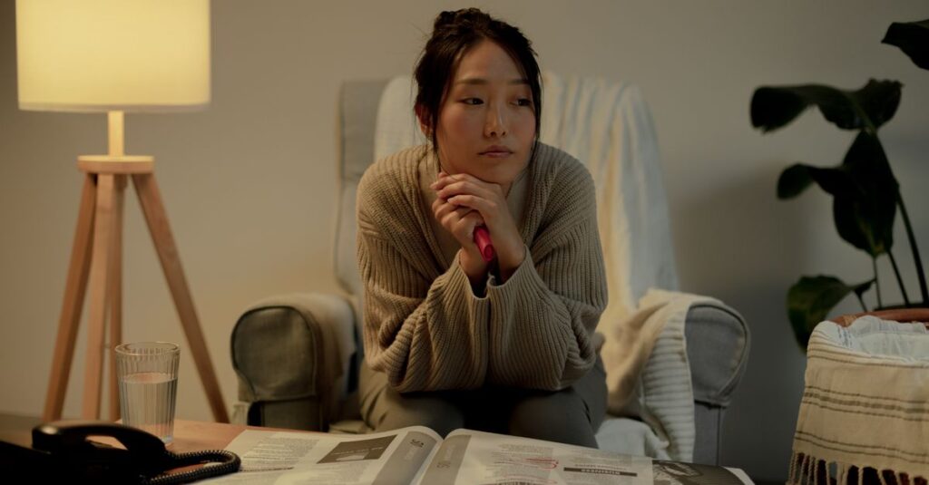 疲れた表情で静かに座る女性。愛されるための努力に消耗した日々を象徴する風景。