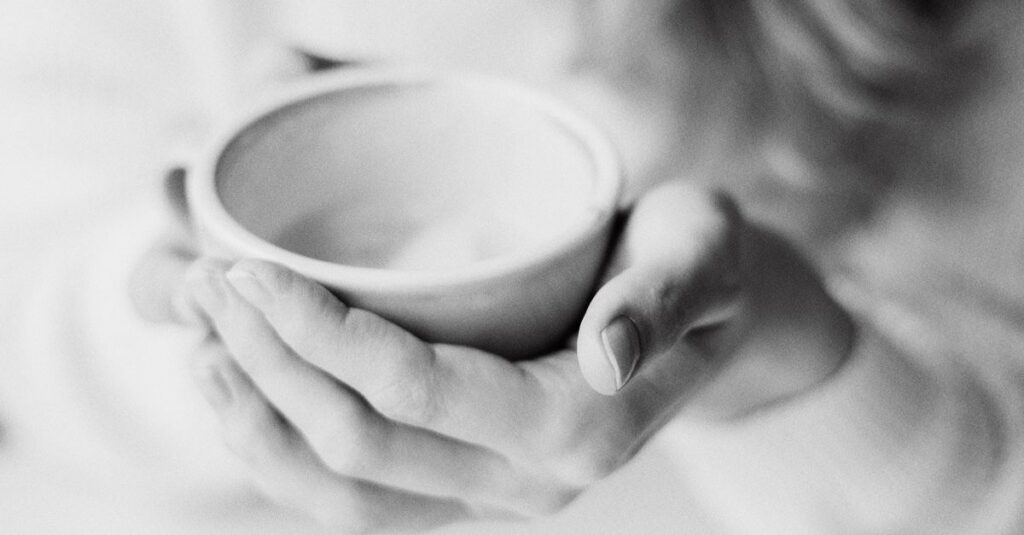 gentle hands holding warm cup quiet safety calm light