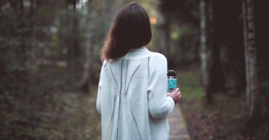 静かな道をひとり穏やかに歩く女性。自分を守る距離を選んだ後の軽やかさを象徴する風景。