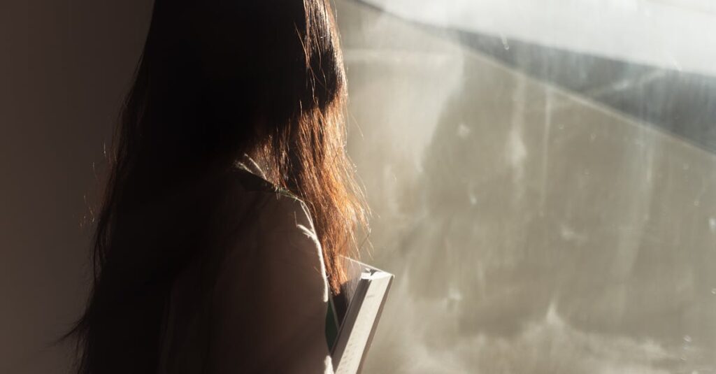 窓辺で静かに何かを手に持つ人。手が止まるのは、心がそこに用があるから。