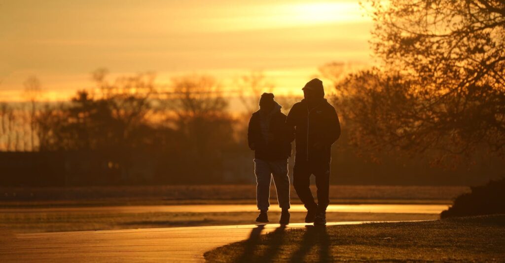 朝の光の中を並んで歩く二人。伴走型セッションを象徴する風景。