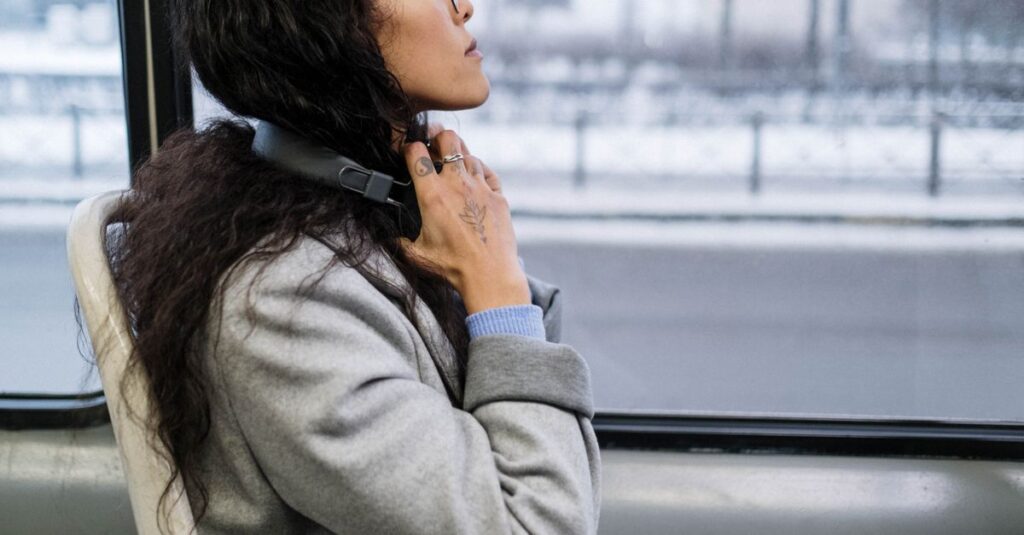 窓辺で静かに話を聞く女性