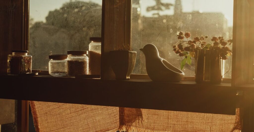 やわらかな光の中で窓の外で突然騒ぎ始める鳥。不思議な体験を象徴する風景。